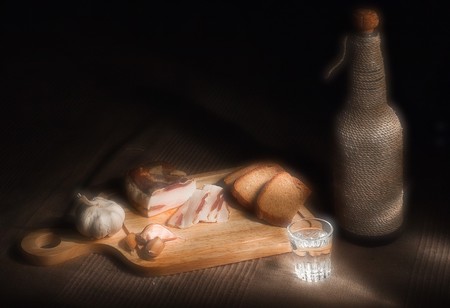 Still-life with garlic, bacon and vodka in glow light の写真素材