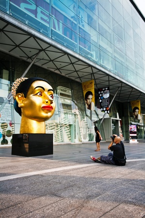 BANGKOK - NOVEMBER 25: Tourist photographing sculpture of Indian woman's head, dedicated to the 80th Birthday of His Majesty King Bhumibol Adulyadej on 25 November 2009.のeditorial素材