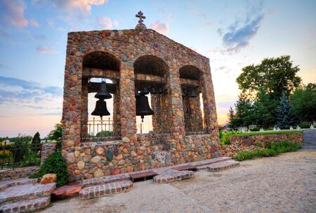 Ancient church bells on sunset sky backgroundの写真素材