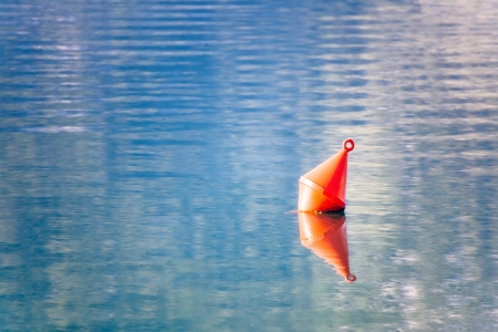 Single red buoy on a calm sea surface の写真素材
