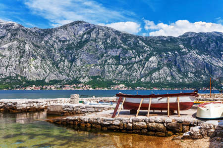 The old boat at the beach in the morning with the sea and mountainsの写真素材