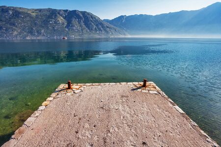 Early misty morning on the beach with sea and mountain views  Kotor bay  Montenegro