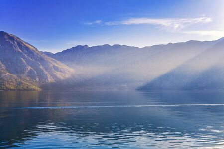 Early misty morning on the beach with sea and mountain views  Kotor bay  Montenegro