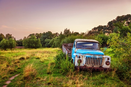 Old lorry in the field before sunsetの写真素材
