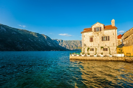 Old house in sunlights at sea on mountains background  Montenegroのeditorial素材