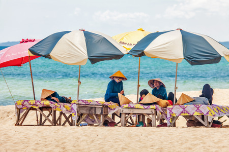 PHU QUOC, VIETNAM - APRIL 21, 2014  Beach masseuses resting  waiting of tourists in the shade of umbrellas at Long beach on Phu Quoc island, Vietnam  のeditorial素材