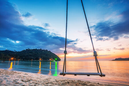 Swing on beautiful sunset at the beach の写真素材