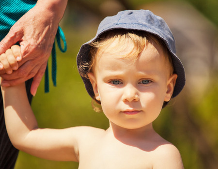 Portrait of a little boy, whose grandmother holds the handの写真素材
