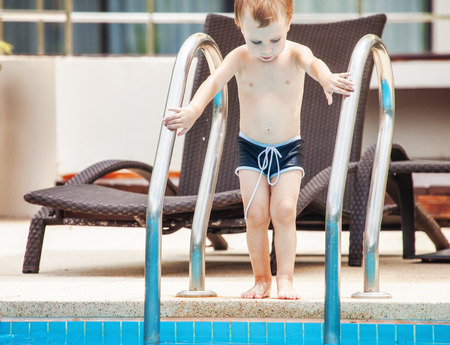 little boy in the swimming pool in hot dayの写真素材