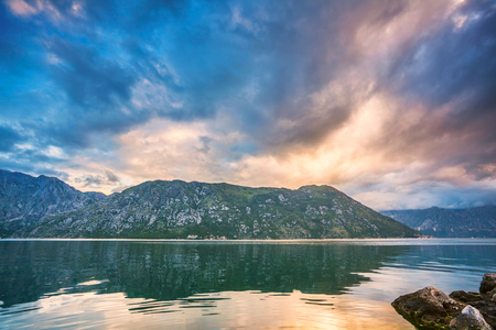 Gloomy sea sunset on mountains backgroundの写真素材