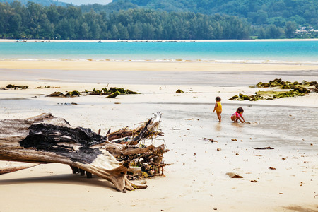 PHUKET, THAILAND- OCTOBER 24, 2014: Thai children play on the Nai Yang beach of Phuket island before sunset. Phuket is located on the west coast of Thailand in the Andaman Sea of the Indian Oceanのeditorial素材