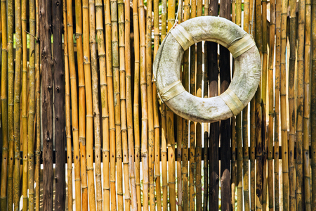 old lifebuoy at the bamboo fenceの写真素材