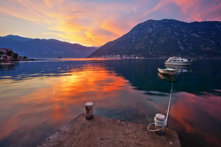 The boat in the sea at sunset with mountains in the background. The Bay of Kotor. Montenegro.の写真素材