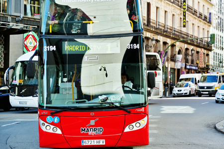MADRID, SPAIN - OCTOBER 27, 2015 : Red tourist bus near Plaza de la Puerta del Sol. Madrid City Tour is the official touristic bus service that shows the city.のeditorial素材