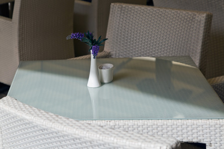 Lilac flowers in a white vase on a table of street cafeの写真素材