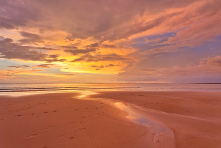 Tropical beach in ebb time on sunset backgroundの写真素材
