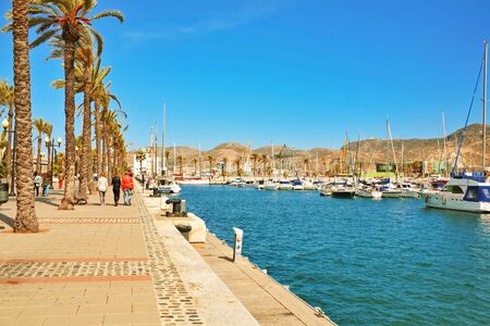 CARTAGENA, SPAIN - APRIL 30, 2016: promenade with palm trees, pier with many yachts in the bay of Cartagena city, region of Murcia.のeditorial素材