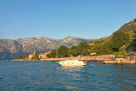 Speed boat in the sea at sunset with mountains in the background. The Bay of Kotor. Montenegro.のeditorial素材