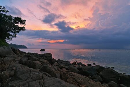 Gloomy tropical sunset at the rocks beach. Thailand 
