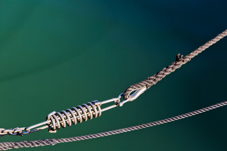 Stainless steel snap shackle used on a yacht on sea background