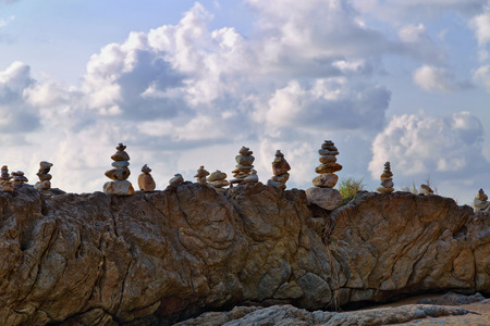 Stacks of stones at rock under cloudy sky, Khao Lak, Thailand.の写真素材