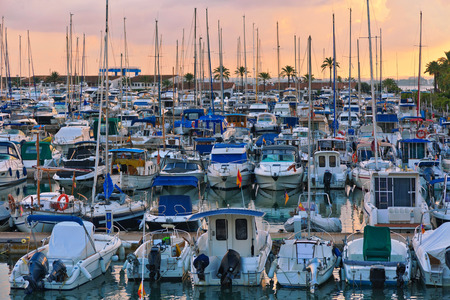 Stunning view of luxury yachts at the pier against the sunset. Yachts and boats anchored in marina.