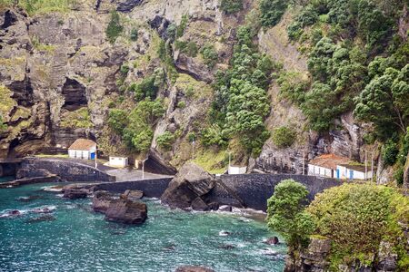 Small bay for fishing boats on the background of high cliffs on Sao Miguel island, Azores, Portugal