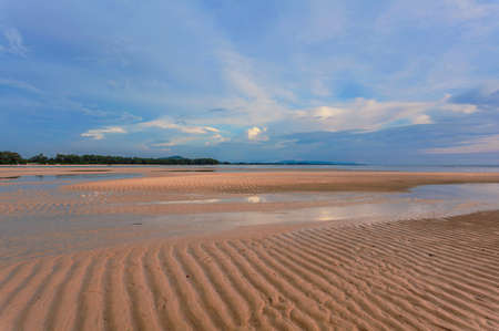 Tropical beach in ebb time in sunset lightsの写真素材