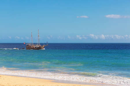 Pleasure tourist ship near the famous beach of Praia dos Caneiros. Algarve.Portugal