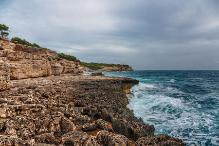 Rocky beach under a gloomy dramatic sky. Mallorca island, Spain Mediterranean Sea, Balearic Islands.の写真素材