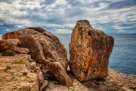 Rocky beach under a gloomy dramatic sky. Mallorca island, Spain Mediterranean Sea, Balearic Islands.の写真素材