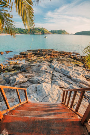 fisheye view on wooden steps to the beach and tropical sea under blue skyの写真素材