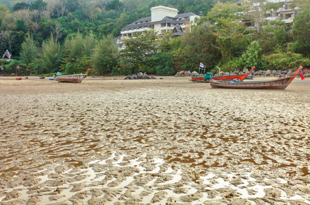 Boat on the beach at sunset in tide time. Nai Yang beach. Phuket. Thailandの写真素材