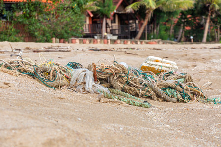 Outdoor view of fishing net and ropes garbage in the White sand beach on Koh Chang island in Thailandの写真素材