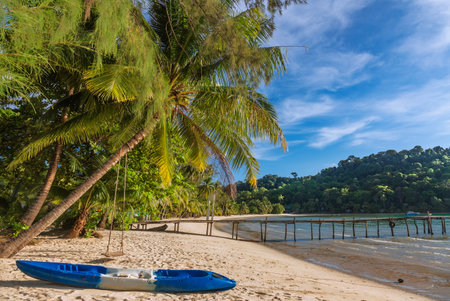 Beautiful landscape with kayak and palm trees and low tide sea at Bang Bao Bay, which is a beautiful beach on Koh Kood island, Trat, Thailandの写真素材