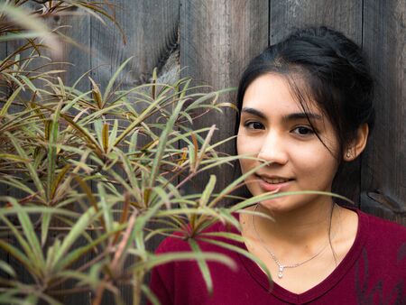 Asian woman standing and have a big smile, wooden backgroundの写真素材