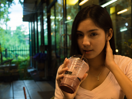 Asian woman drinking a blueberry smoothiesの写真素材