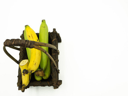 Bunch of banana in the wooden basket, isolated white background, top view, copy spaceの写真素材