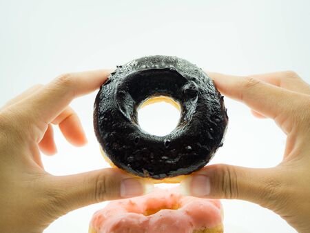 Woman's hand holding donut on white backgroundの写真素材