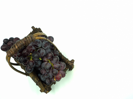 Bunch of grape in the wooden basket, isolated white background, top view, copy spaceの写真素材
