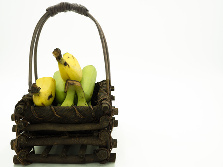 Bunch of banana in the wooden basket, isolated white backgroundの写真素材