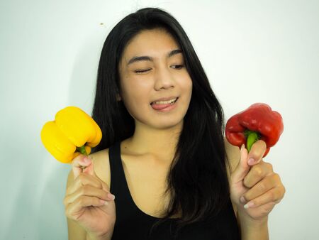 Asian woman holding paprika on the white background