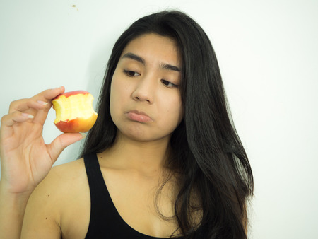 Asian woman eating red apple on white backgroundの写真素材