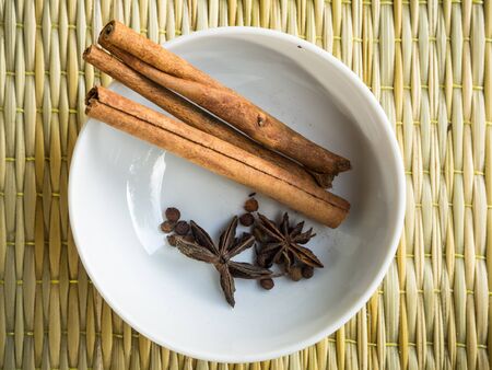 Cinnamon in the white cup on the brown mat