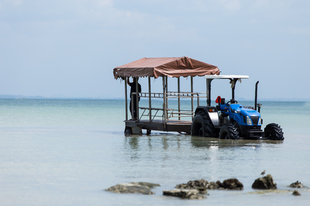 A bule tractor with a boat trailer on in the seaの写真素材