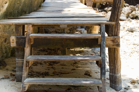 A close up shot of some old weathered beach stairs covered in sandの写真素材