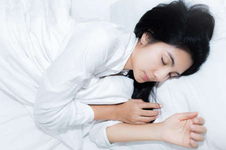 Happy young beauty women sleeping and smile on bed in the morningの写真素材