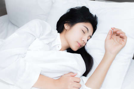 Happy young beauty women sleeping and smile on bed in the morningの写真素材