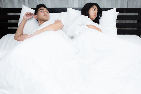 Unhappy couple having problems at bedroom in the morningの写真素材