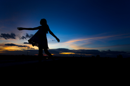 Silhouette of woman posing at sunset or sunriseの写真素材